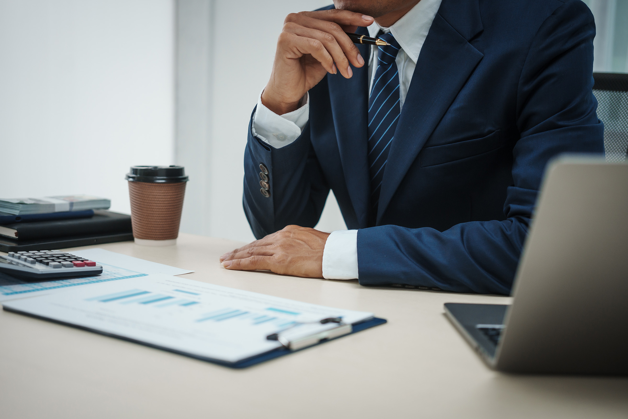 Credit analyst reviewing financial documents and business data at a structured underwriting desk