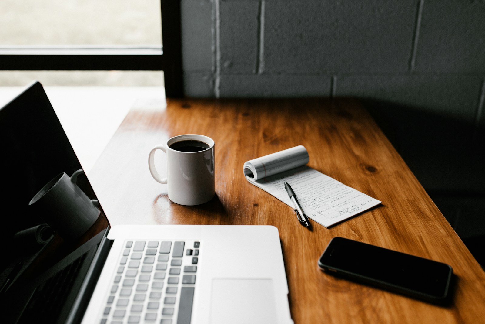 An independent consultant working beside a notebook and laptop