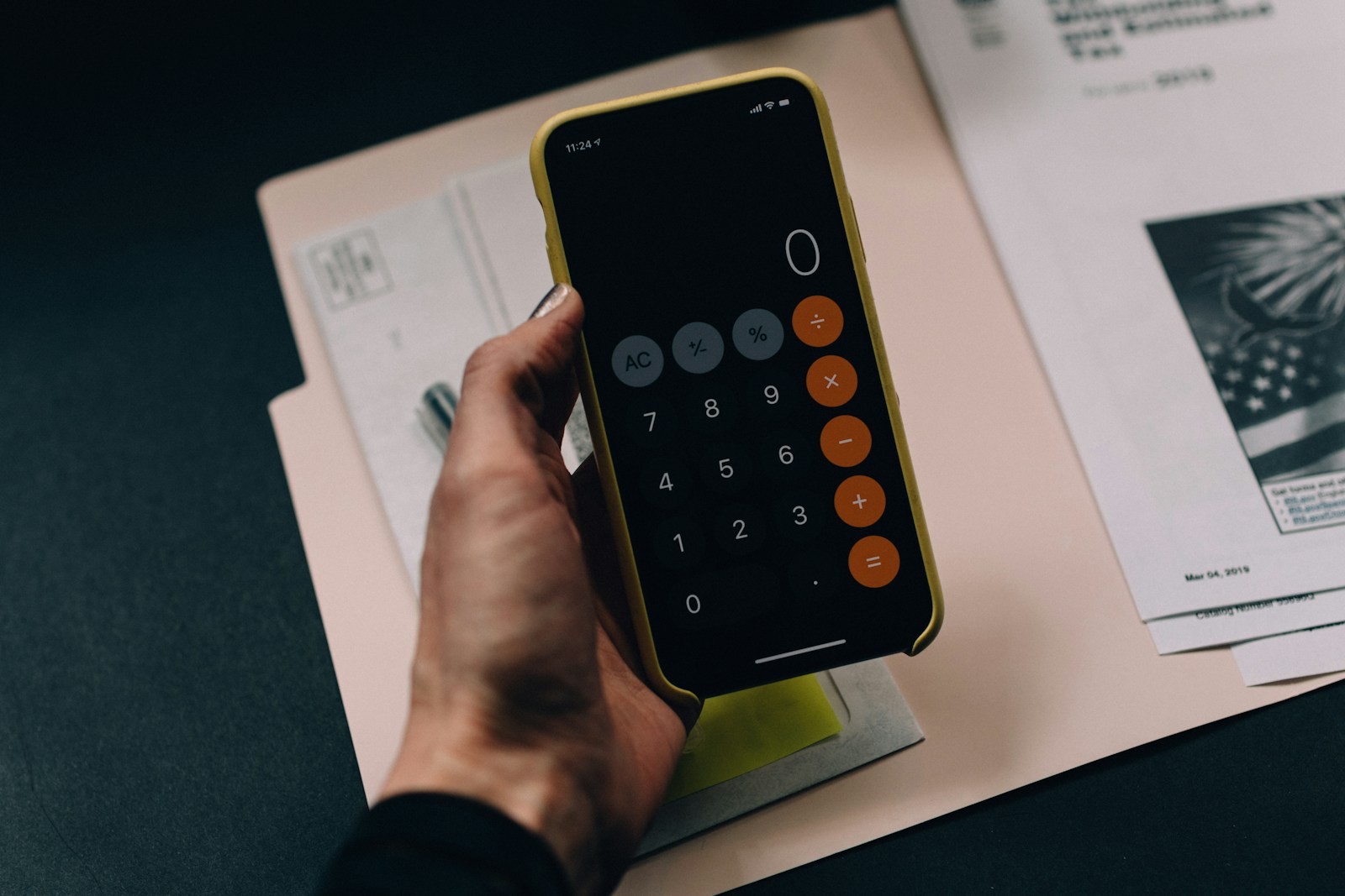 Financial planning documents, calculator, and laptop on a desk